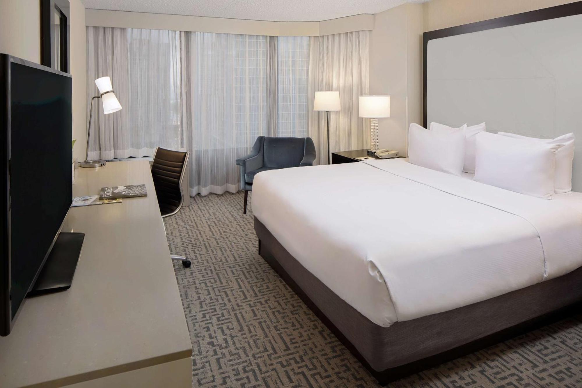 Nichtraucher Suite mit Kingsize-Bett und Blick auf die Stadt.