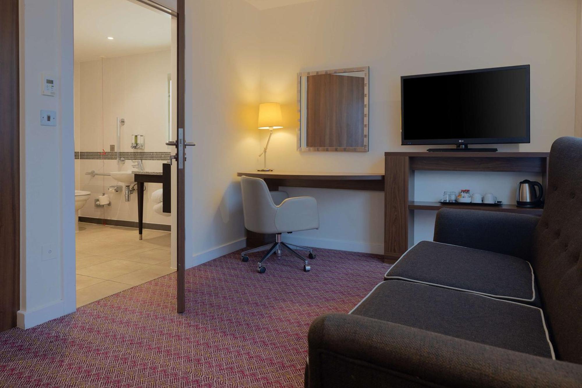Habitación con cama grande y vistas a la ciudad adaptada para personas de movilidad reducida