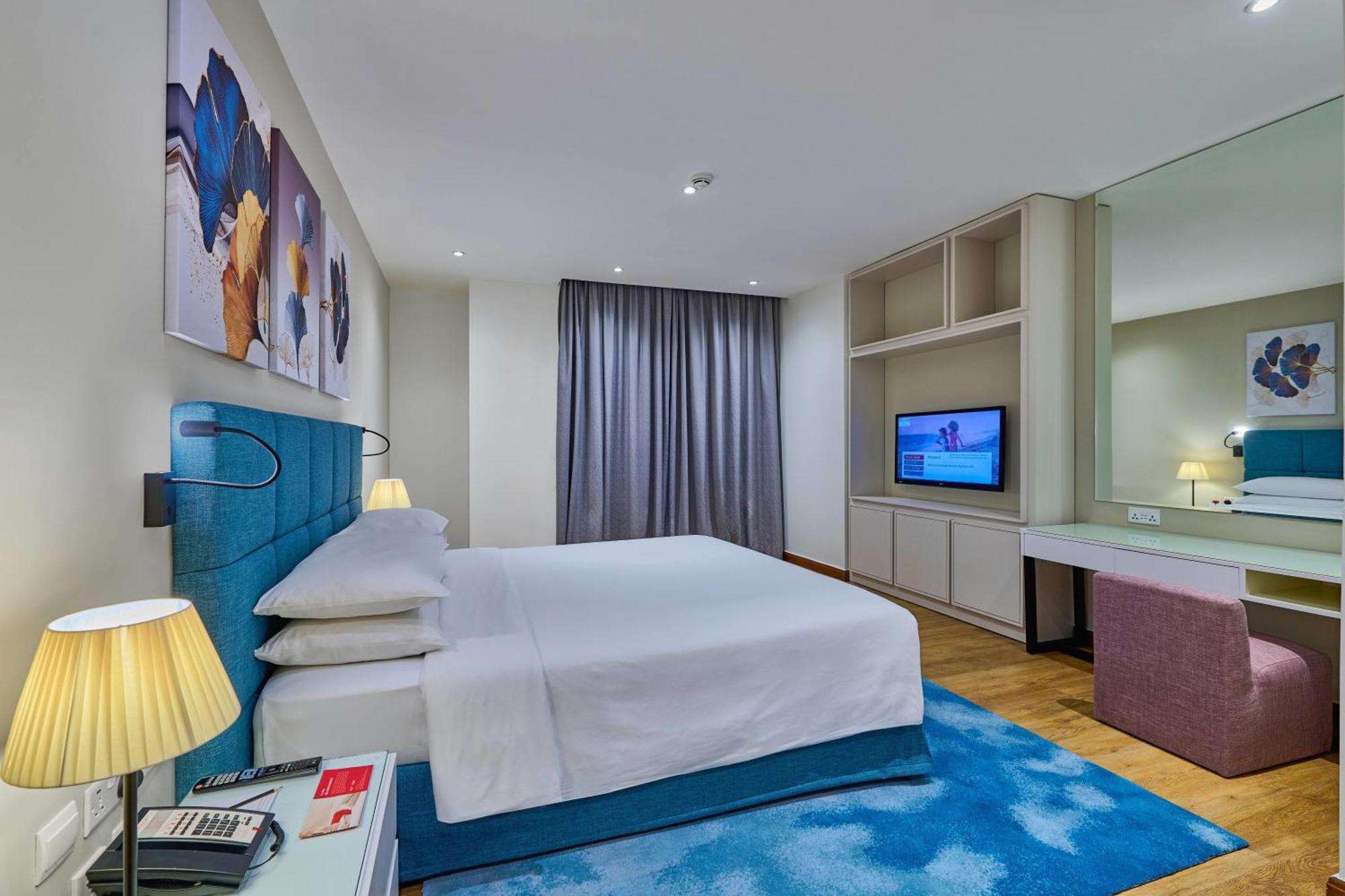 Suite met 1 slaapkamers met kingsize bed en balkon en gedeeltelijk uitzicht op zee