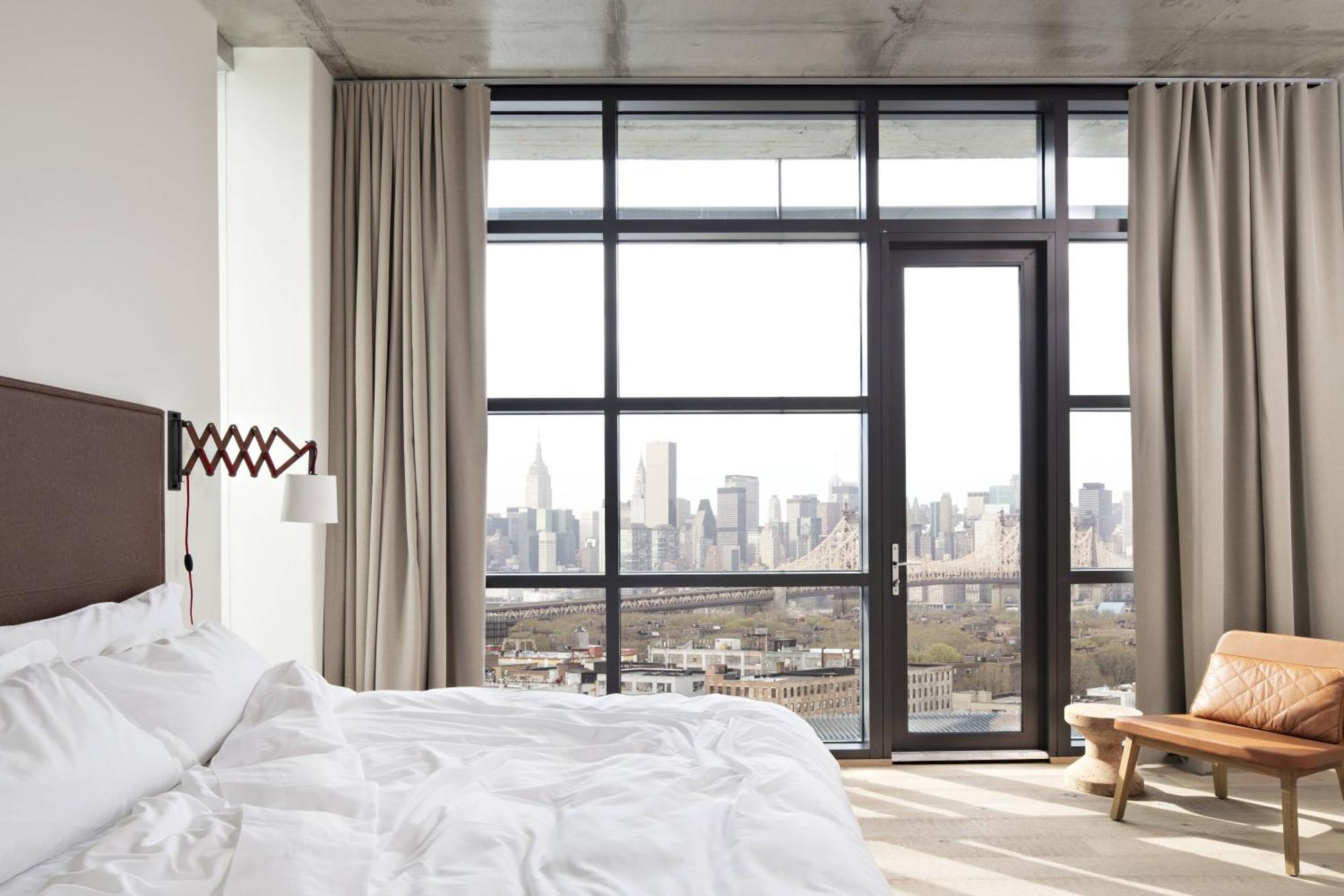 Habitación de esquina con cama extragrande y balcón con vistas a Manhattan